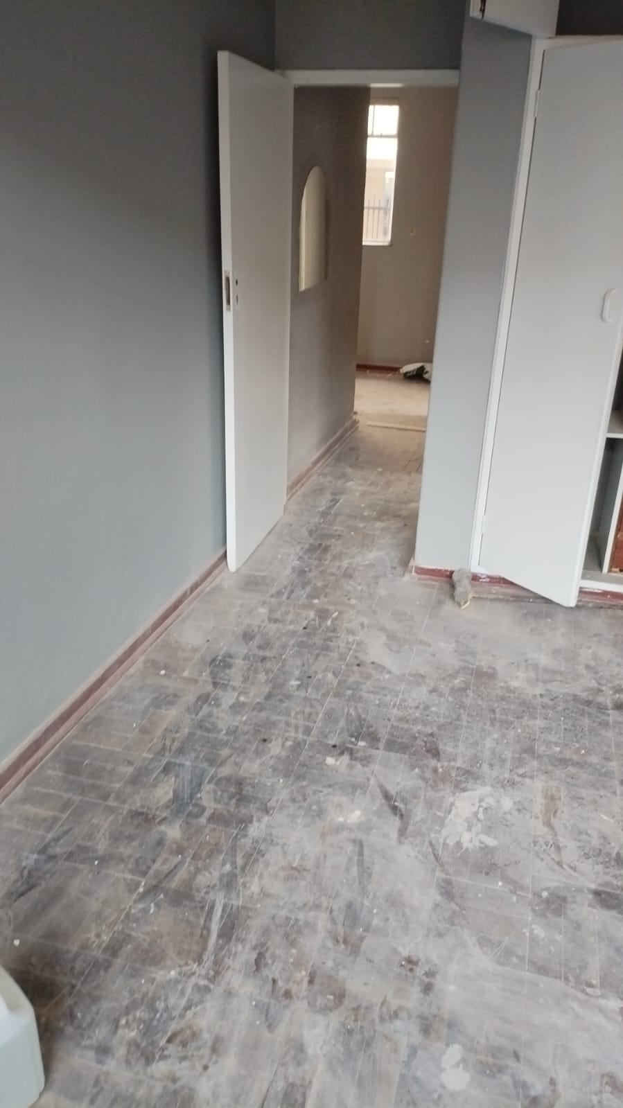 Vacant unit with damaged parquet flooring before renovation