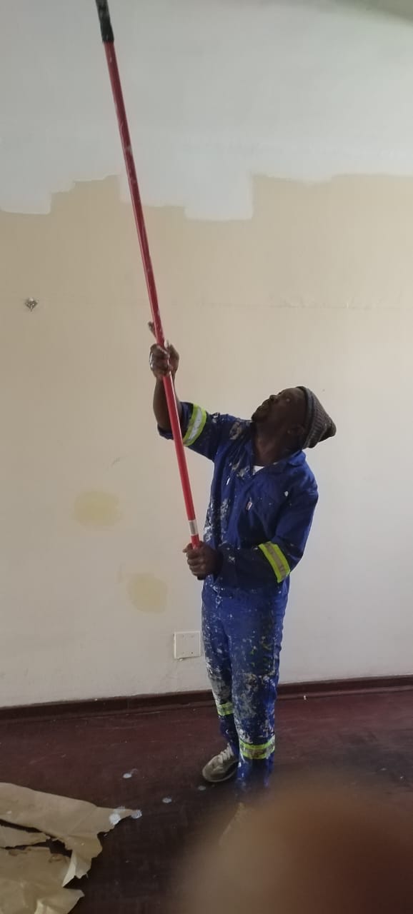Painter applying ceiling coat